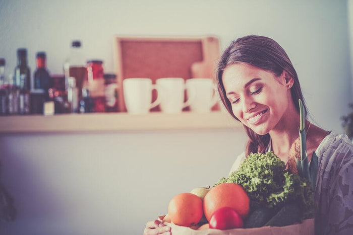 women carrying a arm full of produce